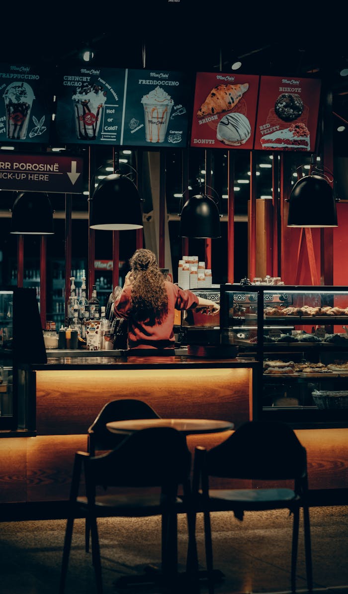 heros-img Warmly lit café with a barista working behind the counter, creating an inviting atmosphere.